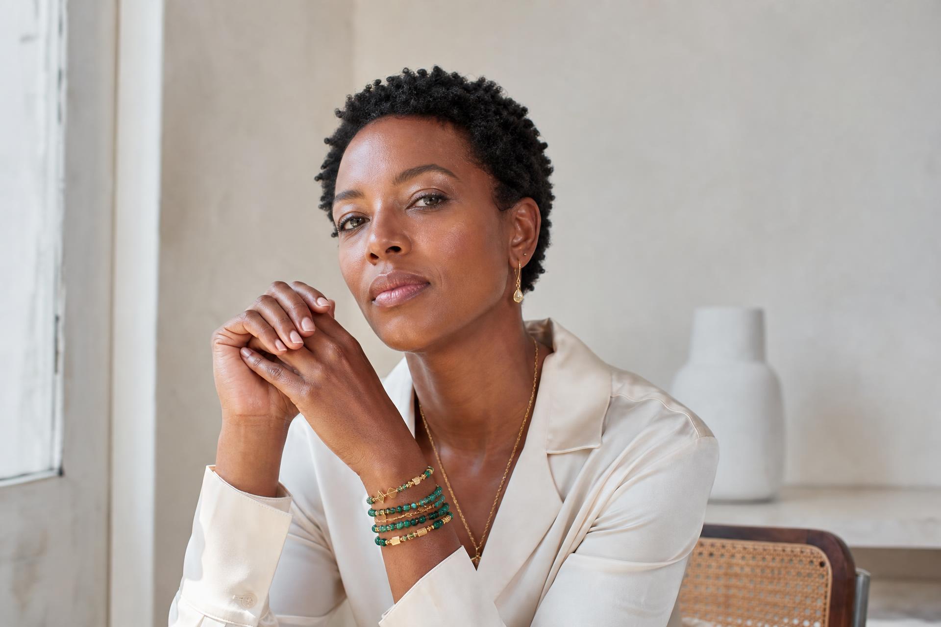 Woman wearing handmade emerald and gold beaded bracelets by Marie's Essentials