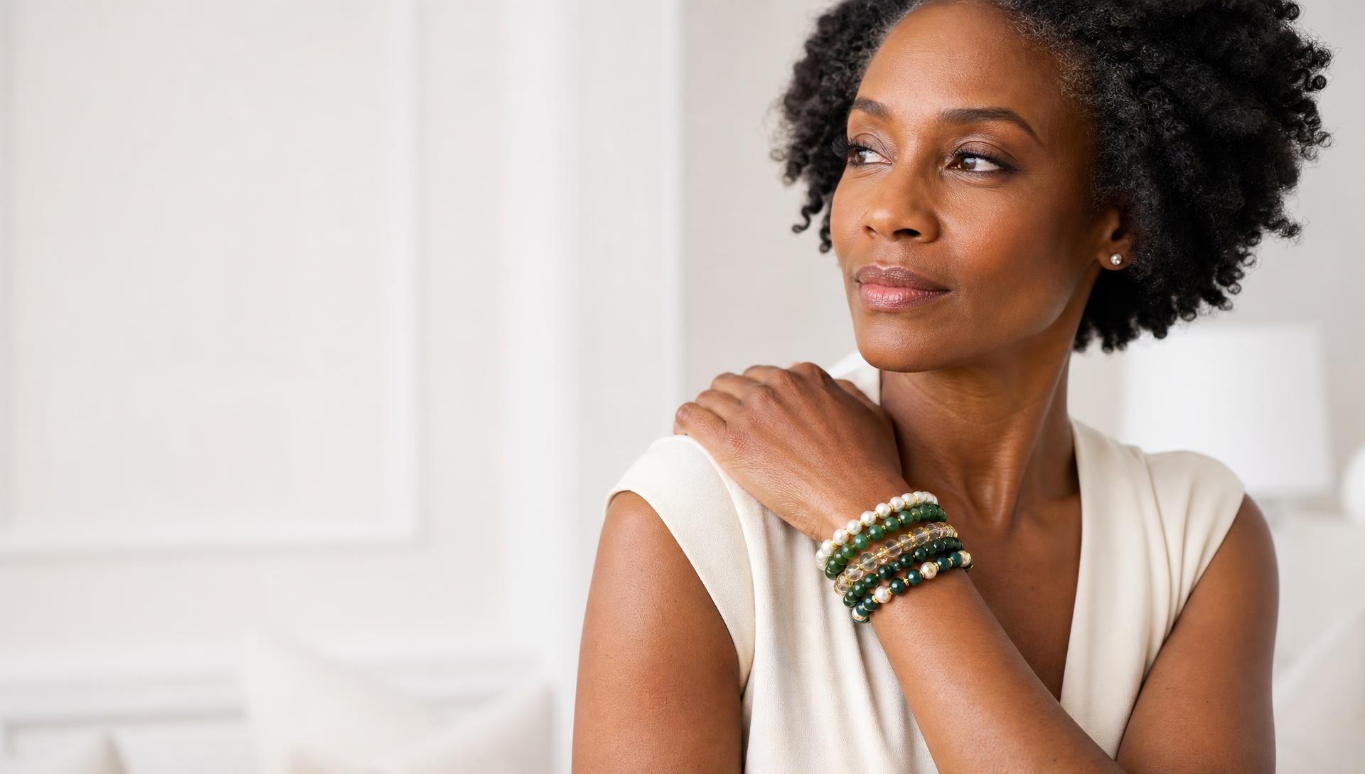 Woman wearing an emerald, pearl and gold handcrafted bracelet stack